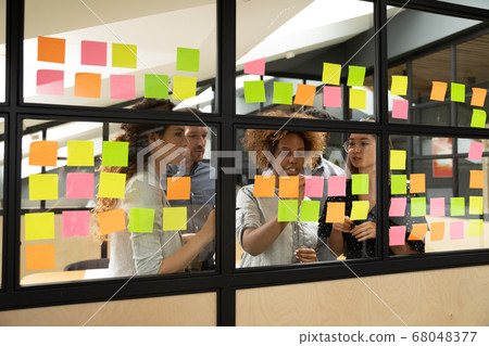 Multiracial business team brainstorm on project write on sticky notes Multiracial business team brainstorm on project write on sticky notes 68048377