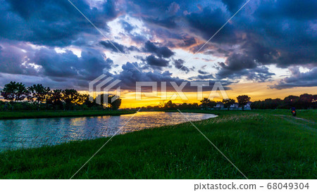 Dark blue stormy cloudy sky with sunset Dark blue stormy cloudy sky with sunset 68049304