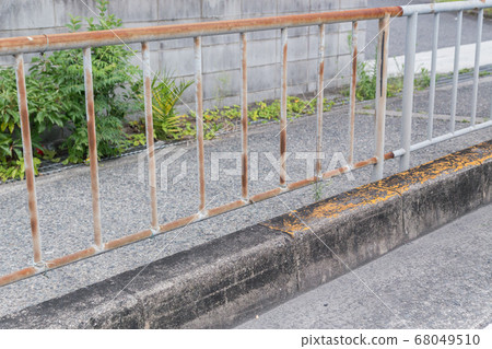 Rusted sidewalk fence 68049510