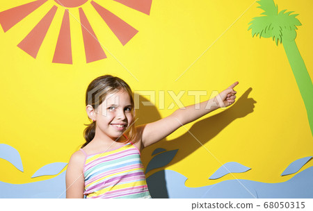 Little girl in a swimsuit on the beach plays, smiles. Child on the equipped beach of Italy. The Little girl in a swimsuit on the beach plays, smiles. Child on the equipped beach of Italy. The 68050315