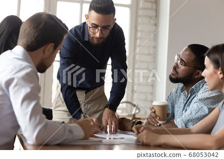 Serious male boss analyzing financial report at group corporate briefing 68053042