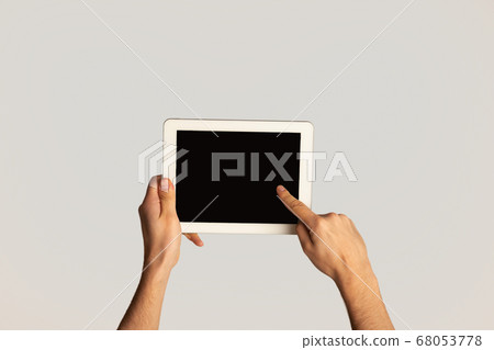 Unrecognizable man touching screen of modern tablet computer on light background, mockup for design Unrecognizable man touching screen of modern tablet computer on light background, mockup for design 68053778