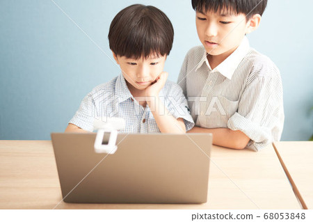 A boy staring at a PC screen A boy staring at a PC screen 68053848