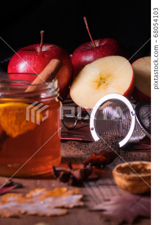 Dark wooden table with 2 glasses of tea with fall, autumn decoration  68054103