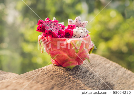 Pieces of sliced dragon fruit in the form of a star on an old withered background Pieces of sliced dragon fruit in the form of a star on an old withered background 68054250