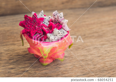 Pieces of sliced dragon fruit in the form of a star on an old withered background Pieces of sliced dragon fruit in the form of a star on an old withered background 68054251
