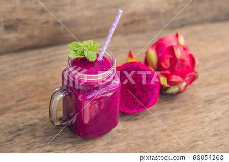 Smoothies of a red organic dragon fruit on an old wooden background Smoothies of a red organic dragon fruit on an old wooden background 68054268