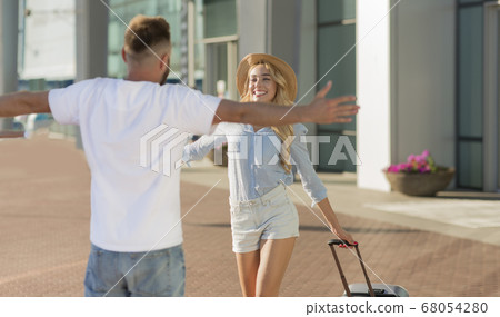 Man picking up his girlfriend near airport building Man picking up his girlfriend near airport building 68054280