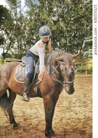 Vintage photo of young girl spending sometime with her horse. Love and friendship concep 68055025