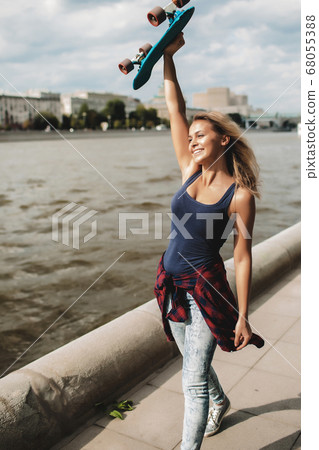 girl posing with skate board 68055388