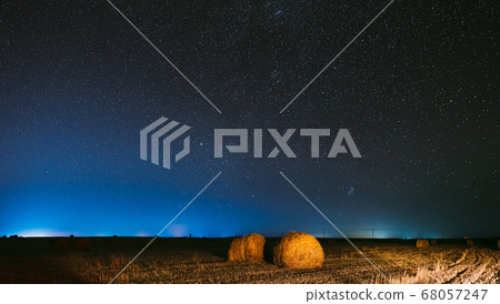 Night Starry Sky Above Haystacks In Summer Agricultural Field. Night Stars Above Rural Landscape With Hay Bales After Harvest. Agricultural Panorama 68057247