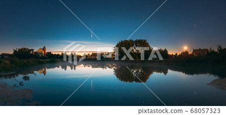 Dobrush, Belarus. Comet Neowise C2020f3 Anf Rising Moon In Night Starry Sky Reflected In Small Lake Waters. Dobrush, Belarus. Comet Neowise C2020f3 Anf Rising Moon In Night Starry Sky Reflected In Small Lake Waters. 68057323