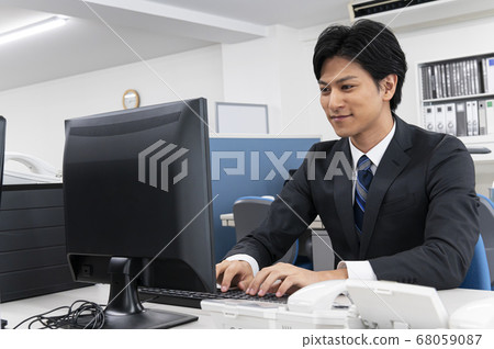 Young male businessman doing disc work with a personal computer 68059087