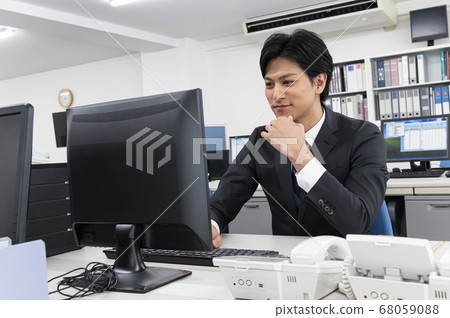 Young male businessman doing disc work with a personal computer 68059088