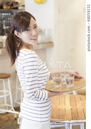 Cafe clerk carrying water Cafe clerk carrying water 68059231
