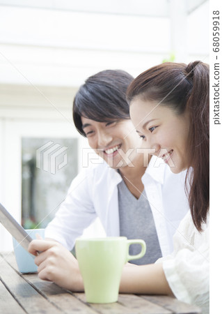 Couple looking at a tablet PC on the terrace 68059918