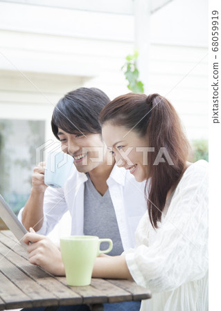夫婦在露台上看著平板電腦 68059919