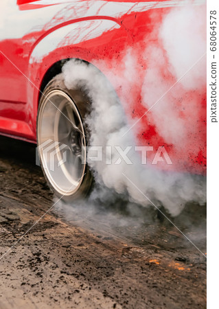 Drag racing car burns rubber off its tires in 68064578