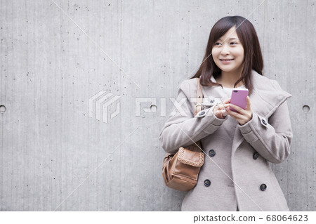 A woman carrying a cell phone mail A woman carrying a cell phone mail 68064623