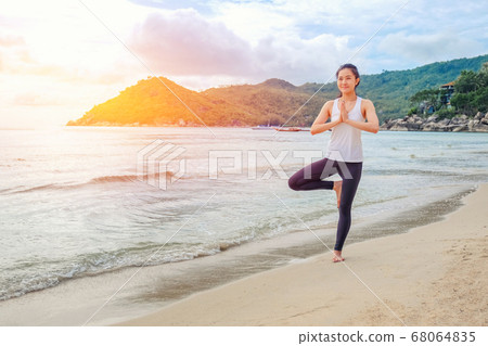 Young beautiful woman practicing yoga on the beach Young beautiful woman practicing yoga on the beach 68064835