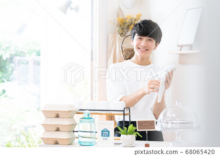 A man working as a cafe clerk [takeout] 68065420