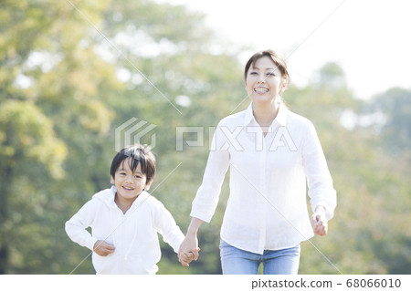 Parent and child running in the park Parent and child running in the park 68066010