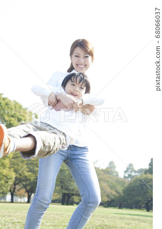 Parent and child playing in the park Parent and child playing in the park 68066037