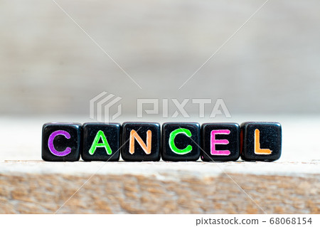 Black bead with color letter in word cancel on wood background Black bead with color letter in word cancel on wood background 68068154