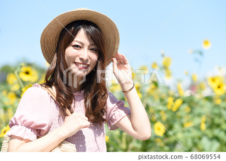向日葵田和微笑的年輕女子 68069554