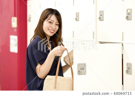 一個把行李放在儲物櫃裡的女人 一個把行李放在儲物櫃裡的女人 68069715