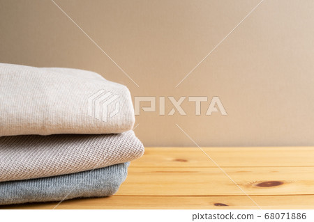 Pile of warm sweater clothes on wooden table. Autumn and winter concept. with copy space 68071886