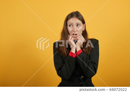 Scared Woman Clenched Hands Into Fists, Holds Them To Face. Fear, Uncertainty Scared Woman Clenched Hands Into Fists, Holds Them To Face. Fear, Uncertainty 68072022