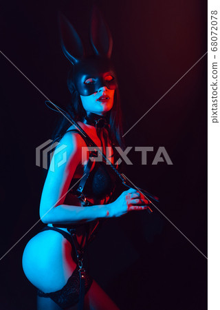 dominatrix mistress girl with sexy ass in harness in Bunny mask with leather Flogger 68072078