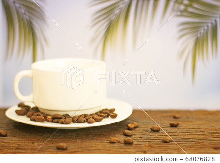 a cup of coffee on wood on blurred palm leaf 68076828