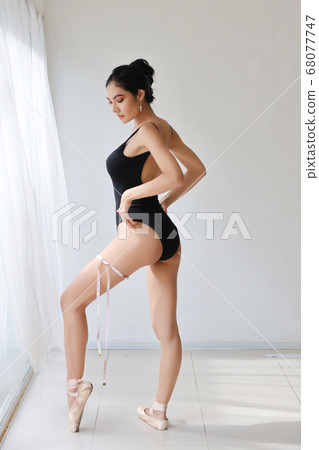 full length healthy and slim woman taking measurements of her body 68077747