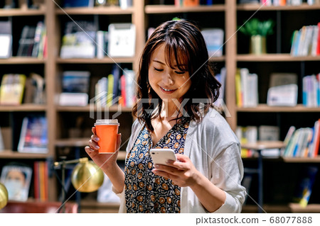 操作智能手機的年輕女商人在辦公室（偶然） 68077888