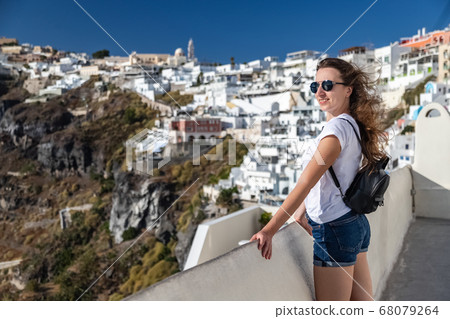 Happy smiling woman tourist traveling on luxury cruise in Mediterranean, Greece, Santorini. Background architecture island sea sky Happy smiling woman tourist traveling on luxury cruise in Mediterranean, Greece, Santorini. Background architecture island sea sky 68079264