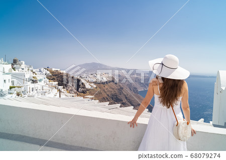 young woman enjoying view of Santorini, Greece young woman enjoying view of Santorini, Greece 68079274