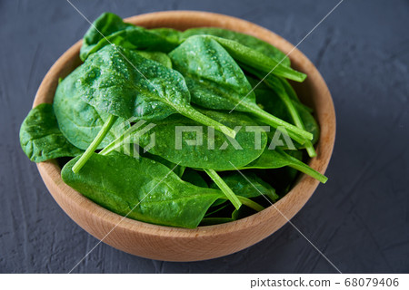 Fresh spinach leaves in wooden bowl on dark 68079406