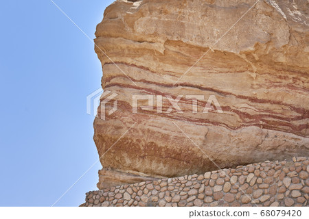 Rock with a soil layers against blue sky Rock with a soil layers against blue sky 68079420
