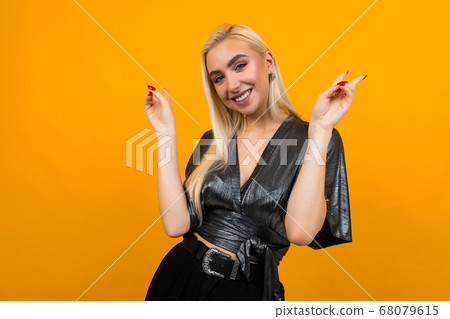 european elegant girl model flirts on a yellow background with copy space 68079615
