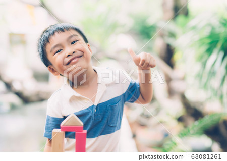 Asian young boy playing wooden block toy on table for creative and development with enjoy. Asian young boy playing wooden block toy on table for creative and development with enjoy. 68081261