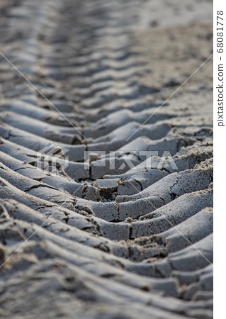 The traces of the tractor wheels on the beach look like the backbone of a large snake. The traces of the tractor wheels on the beach look like the backbone of a large snake. 68081778