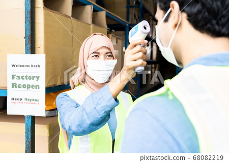 Muslim asian warehouse worker take temperature to Muslim asian warehouse worker take temperature to 68082219