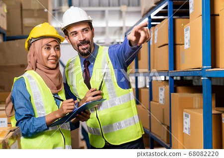 Warehouse manager and muslim worker working Warehouse manager and muslim worker working 68082220
