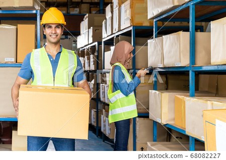 Indian warehouse worker hold cardboard box 68082227