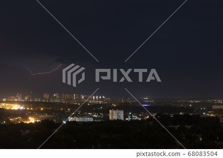 Lightning flashes in the night cloudy sky above the city 68083504