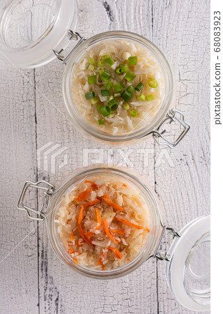Opened jars with sauerkraut on white background Opened jars with sauerkraut on white background 68083923