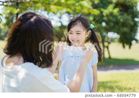 A mother wearing a mask for her child A mother wearing a mask for her child 68084779