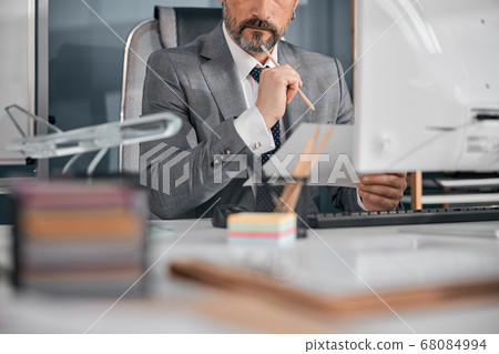 Stylish bearded man working with documents in office 68084994